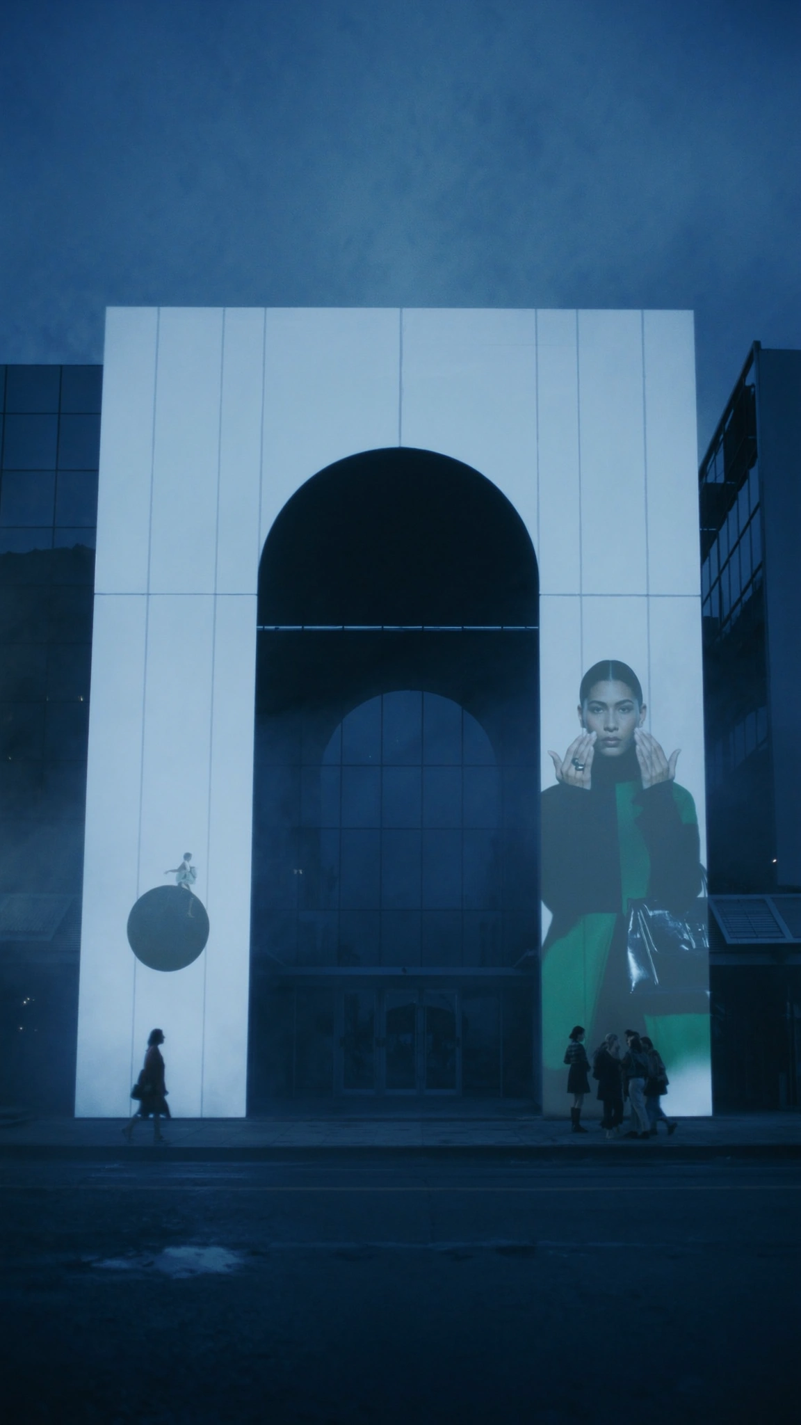 Night fashion campaign projected across an arched architectural facade.