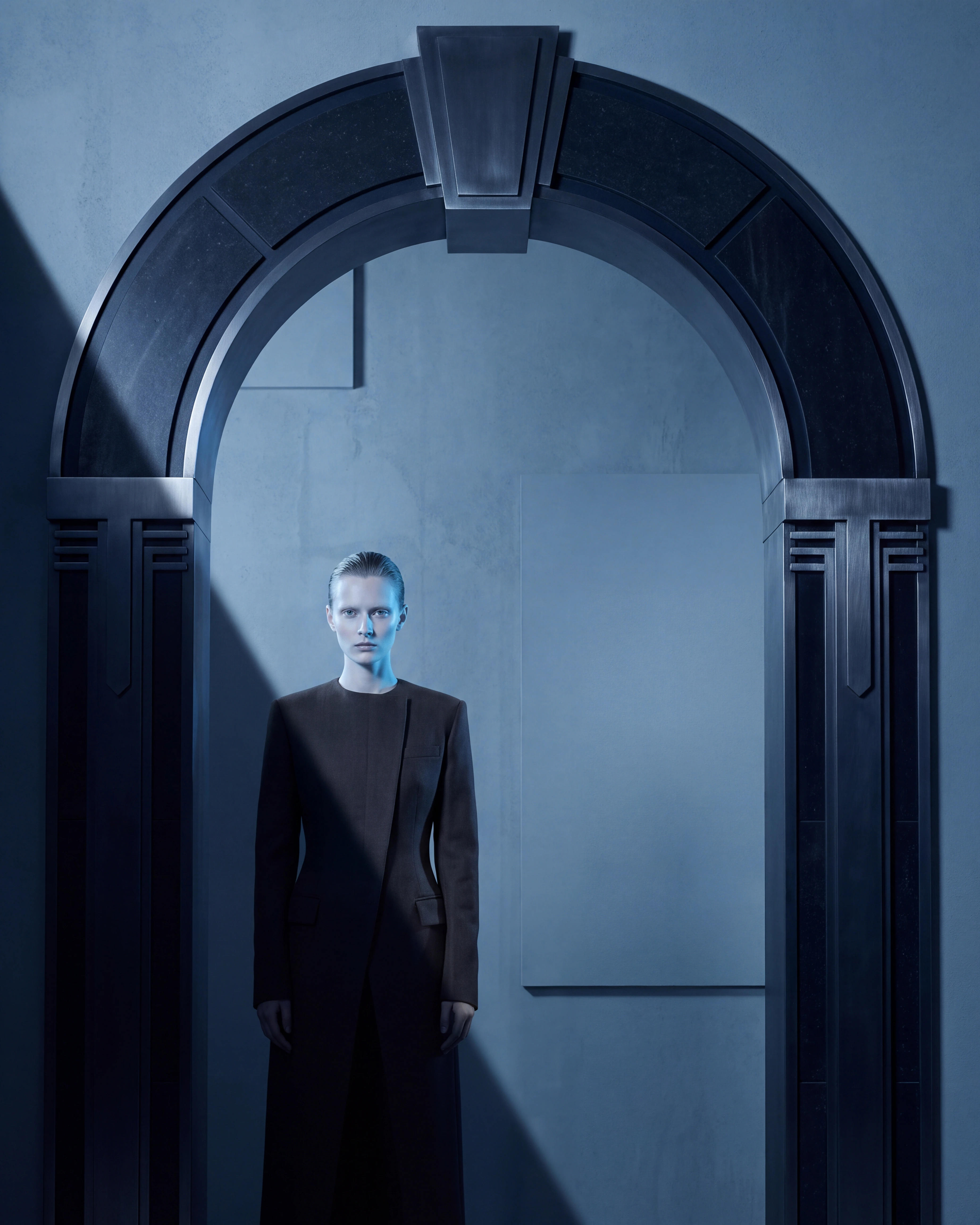 Androgynous model framed by a midnight arch and a single diagonal shadow.