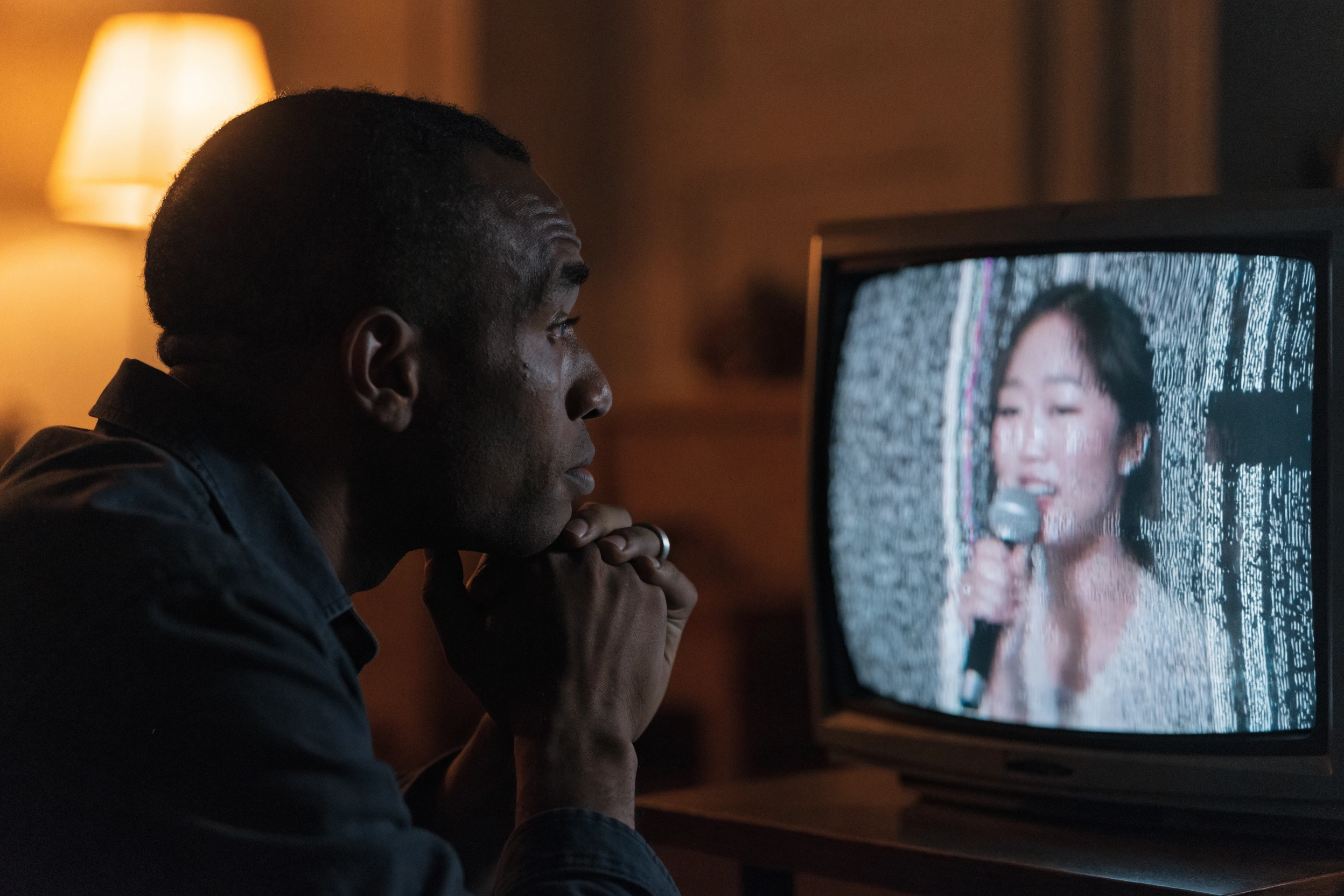A late-night listener watches the live feed from a dark domestic room.